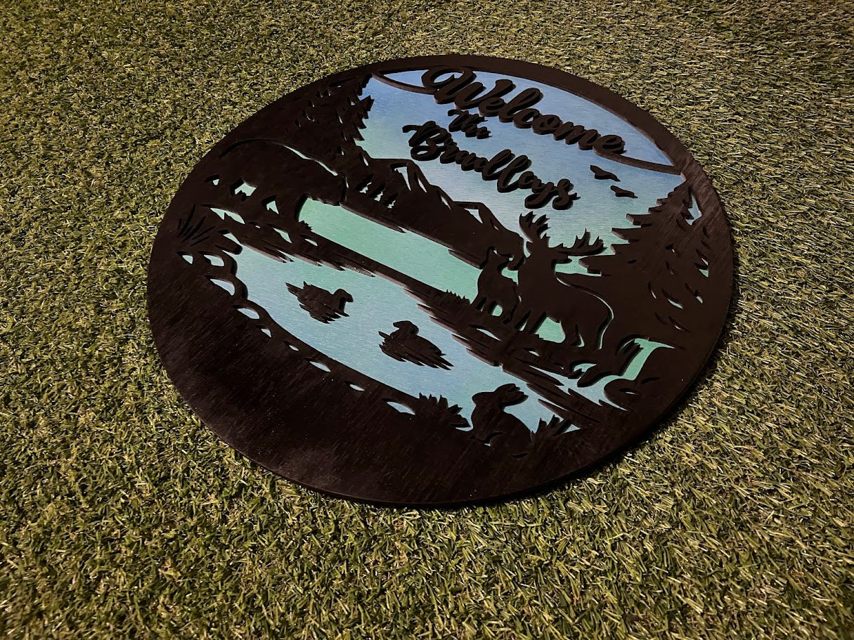 Decorative metal welcome mat with nature-themed cutouts on grass