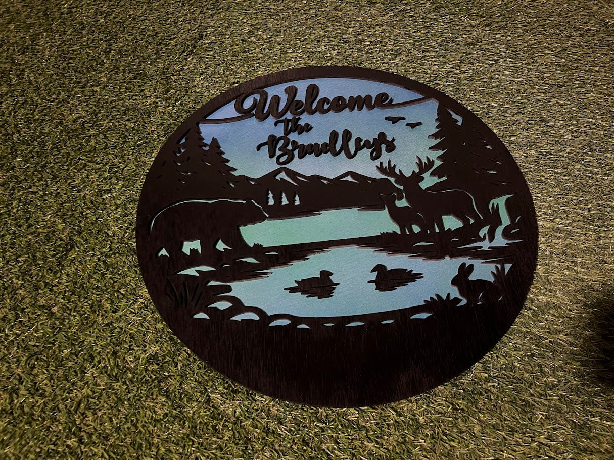 Decorative metal welcome mat with nature-themed design on a textured surface